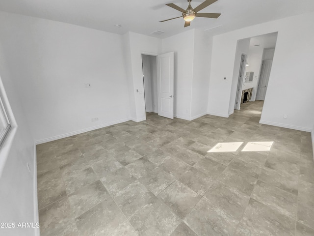 interior space with baseboards and a ceiling fan