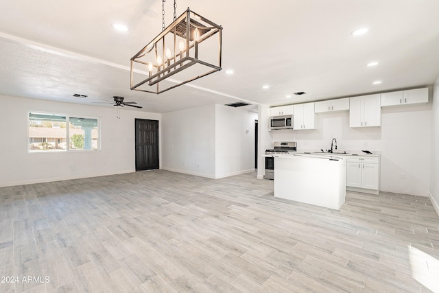 kitchen featuring light hardwood / wood-style floors, a kitchen island, white cabinetry, and appliances with stainless steel finishes