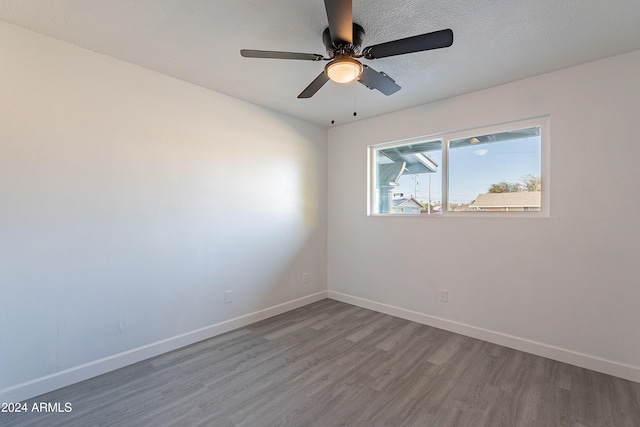 empty room with a textured ceiling, hardwood / wood-style flooring, and ceiling fan