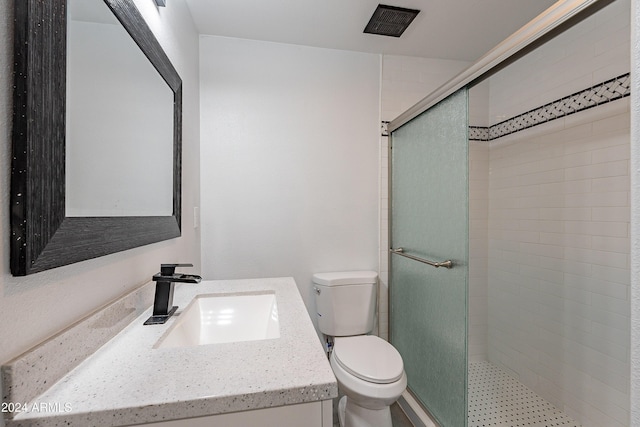 bathroom with vanity, toilet, and a shower with shower door