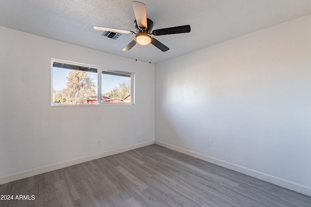 unfurnished room with hardwood / wood-style flooring, ceiling fan, and a textured ceiling