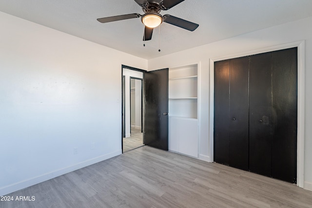 unfurnished bedroom featuring light wood-type flooring, a closet, and ceiling fan