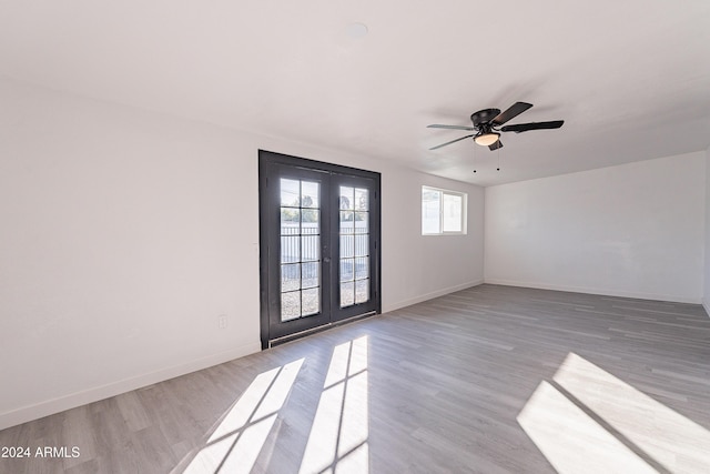 empty room with hardwood / wood-style flooring, ceiling fan, and french doors