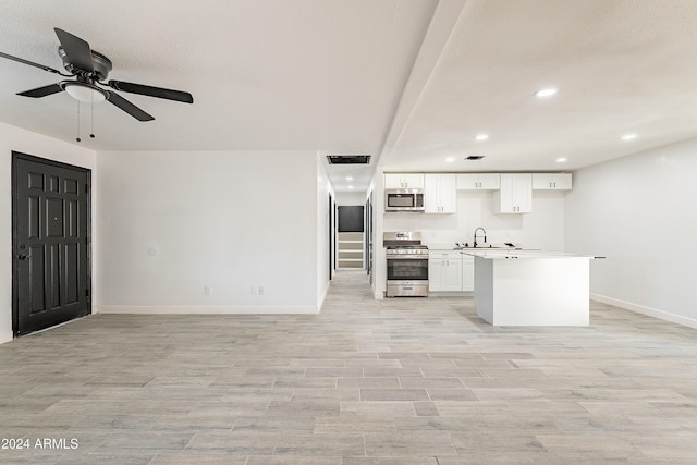 kitchen with sink, ceiling fan, light hardwood / wood-style floors, white cabinetry, and stainless steel appliances