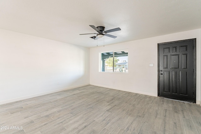 unfurnished room with ceiling fan, light hardwood / wood-style flooring, and a textured ceiling