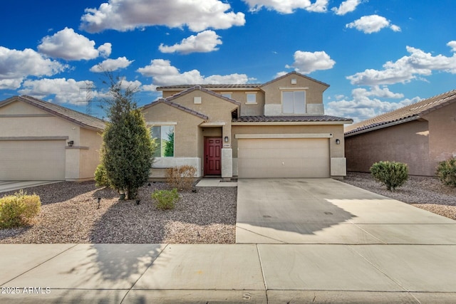 traditional-style house featuring concrete driveway, a tile roof, an attached garage, and stucco siding