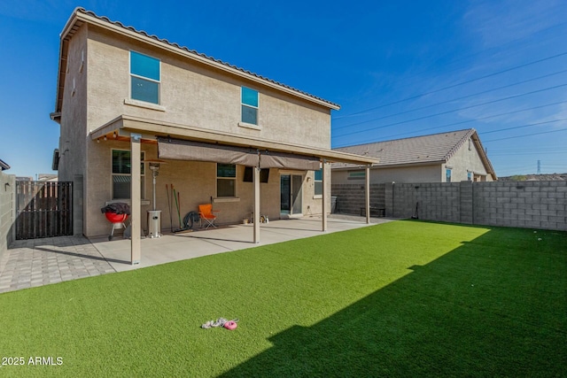 rear view of property with a patio area, a fenced backyard, a yard, and stucco siding