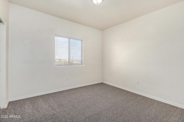 spare room with baseboards and carpet