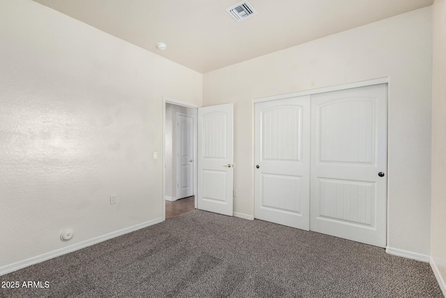 unfurnished bedroom with a closet, baseboards, visible vents, and carpet floors