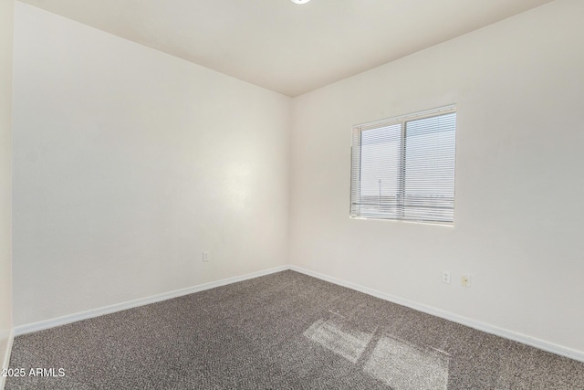 spare room featuring carpet and baseboards