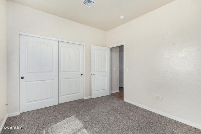 unfurnished bedroom with a closet, visible vents, baseboards, and carpet floors