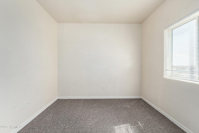 empty room featuring carpet flooring and baseboards