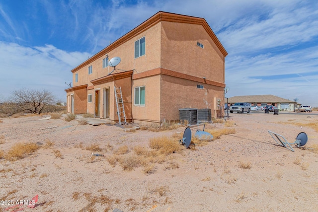 view of home's exterior with stucco siding and cooling unit