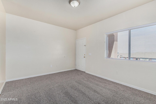 unfurnished room featuring carpet flooring and baseboards