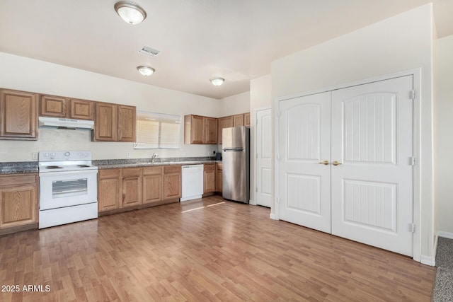 kitchen featuring under cabinet range hood, visible vents, white appliances, and light wood-style floors