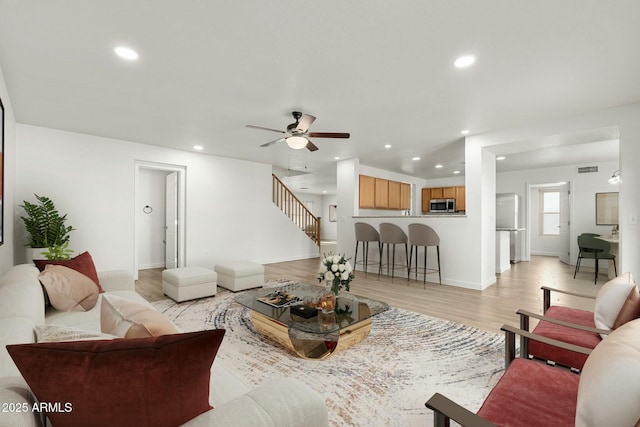 living room featuring light wood-type flooring and ceiling fan