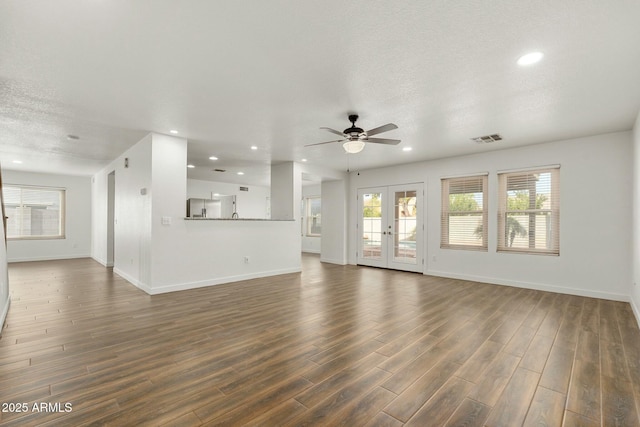 unfurnished living room with a textured ceiling, ceiling fan, french doors, and dark hardwood / wood-style floors