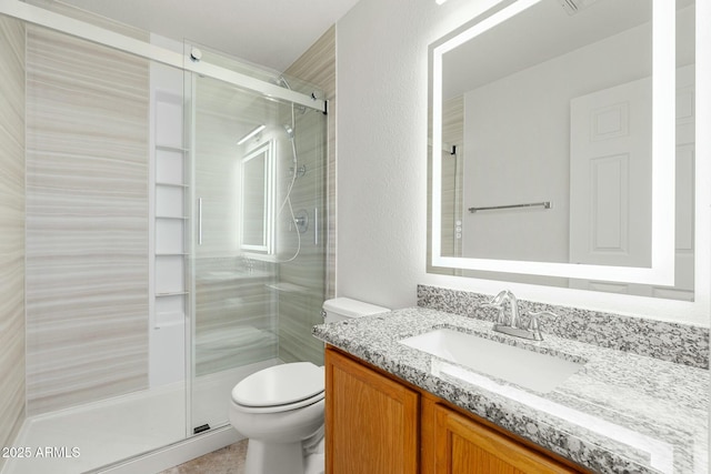 bathroom with vanity, toilet, and an enclosed shower