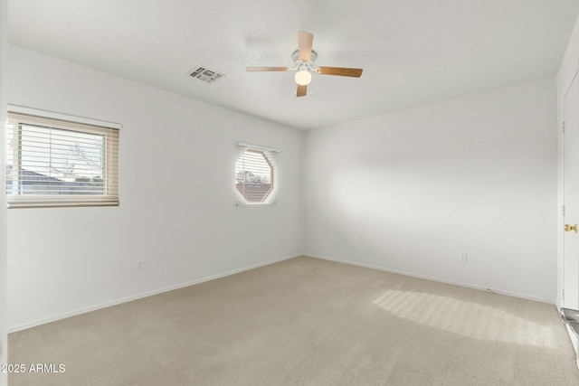 carpeted spare room featuring ceiling fan