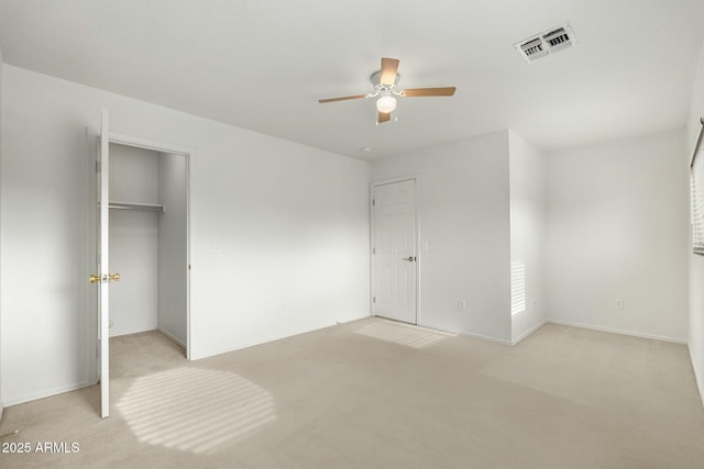 unfurnished bedroom with ceiling fan, a closet, and light carpet