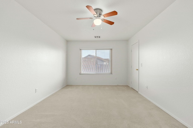 carpeted spare room with ceiling fan