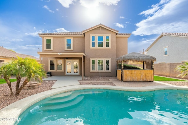 back of house with french doors and a fenced in pool