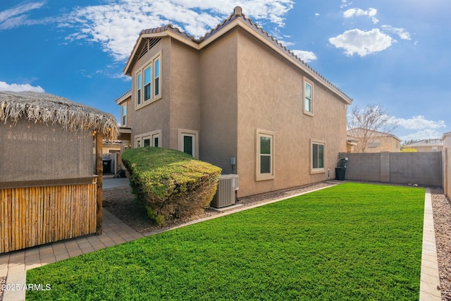 back of house featuring a lawn and central AC