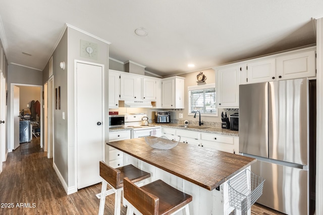 kitchen featuring stainless steel appliances, white cabinets, a sink, and under cabinet range hood