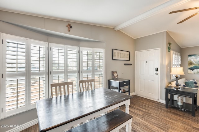 dining space featuring crown molding, lofted ceiling, a ceiling fan, wood finished floors, and baseboards