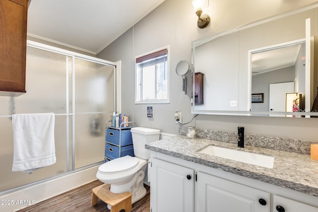 full bathroom featuring toilet, a stall shower, wood finished floors, and vanity