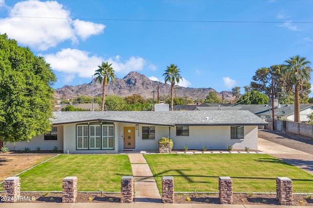 single story home with a mountain view and a front lawn