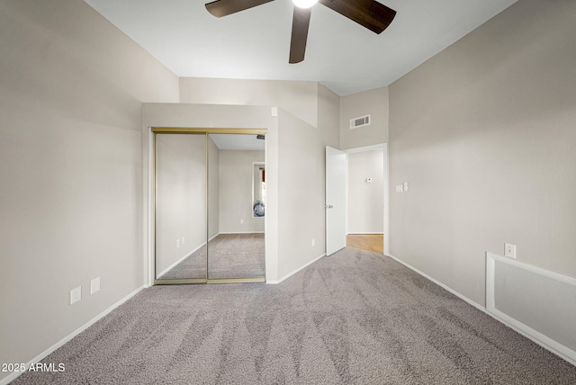 unfurnished bedroom with ceiling fan, a closet, and light carpet