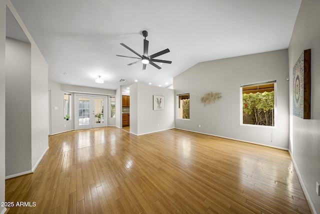 unfurnished living room with vaulted ceiling, ceiling fan, light hardwood / wood-style flooring, and french doors