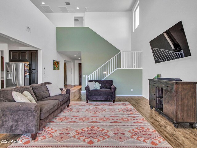 4132 W Tunnel Mine Rd, New River, AZ 85087 - living area with light wood-style floors, stairway, a high ceiling, baseboards, and recessed lighting
