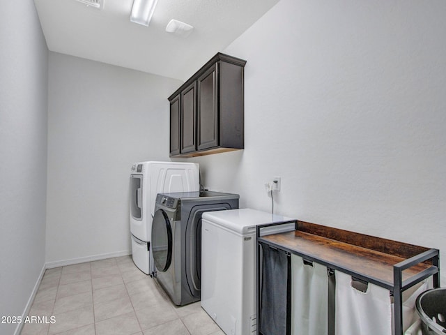 4132 W Tunnel Mine Rd, New River, AZ 85087 - laundry room with cabinet space, washing machine and dryer, baseboards, and light tile patterned floors