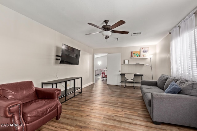 living area featuring ceiling fan, wood finished floors, and baseboards