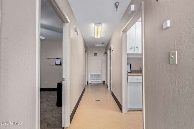 corridor with light floors and a textured wall