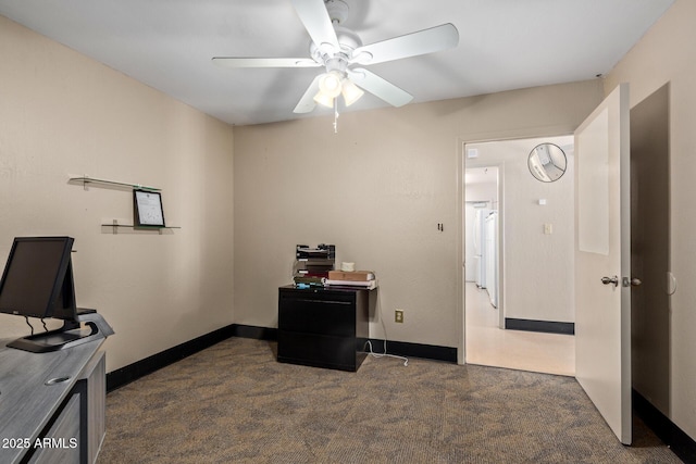 office space featuring dark carpet, a ceiling fan, and baseboards