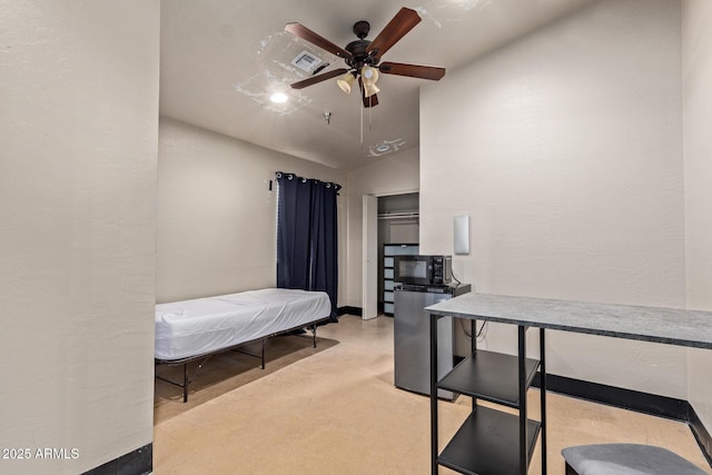 bedroom featuring a textured wall, vaulted ceiling, and ceiling fan