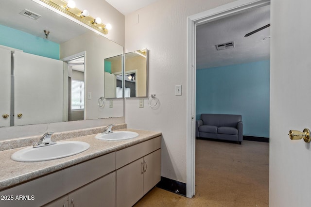 bathroom featuring baseboards, double vanity, and tile patterned floors