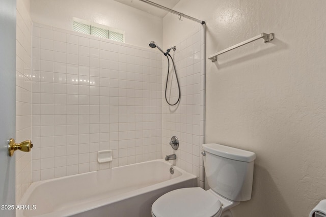 bathroom with toilet, a textured wall, and  shower combination
