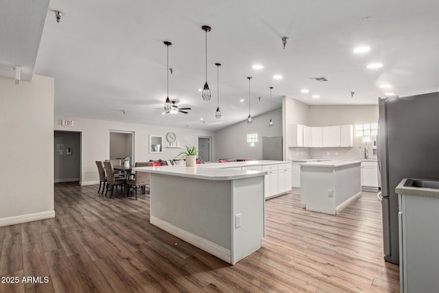 kitchen with a center island, light wood-type flooring, ceiling fan, recessed lighting, and freestanding refrigerator