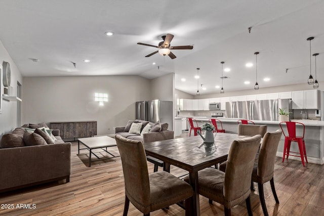 dining room featuring vaulted ceiling, ceiling fan, light wood finished floors, recessed lighting, and baseboards