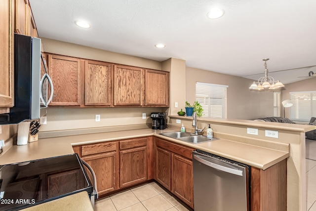 kitchen featuring kitchen peninsula, appliances with stainless steel finishes, an inviting chandelier, light tile patterned flooring, and sink