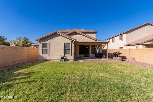 rear view of property featuring a patio and a lawn