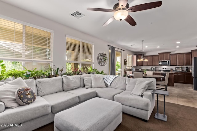 7031 W Lone Tree Trl, Peoria, AZ 85383 - tiled living area featuring recessed lighting, a chandelier, and a ceiling fan