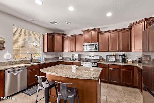7031 W Lone Tree Trl, Peoria, AZ 85383 - kitchen featuring appliances with stainless steel finishes, a center island, recessed lighting, a breakfast bar area, and light tile patterned flooring