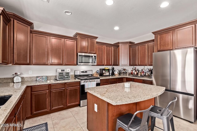 7031 W Lone Tree Trl, Peoria, AZ 85383 - kitchen featuring stainless steel appliances, a breakfast bar area, a center island, light stone countertops, and recessed lighting
