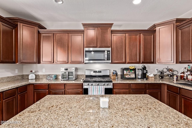 7031 W Lone Tree Trl, Peoria, AZ 85383 - kitchen with appliances with stainless steel finishes, light stone countertops, and recessed lighting