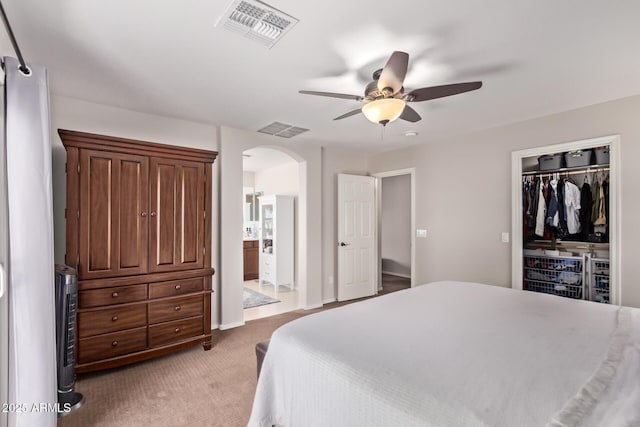7031 W Lone Tree Trl, Peoria, AZ 85383 - bedroom featuring arched walkways, light carpet, ceiling fan, and a closet